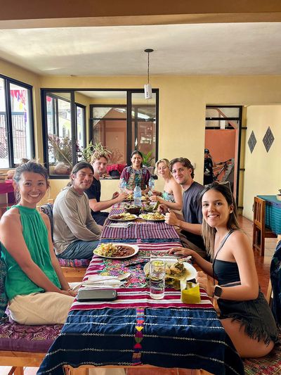Students enjoying the finished Guatemalan dishes students smiling in cooking class at table