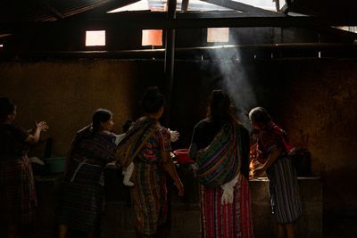 mayan ladies cooking tortillas on traditional stove top