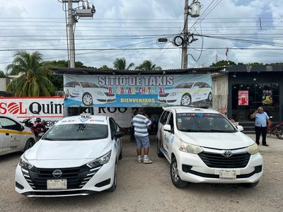 Terminal for Bacalar To Chetumal Taxi Colectivos two parked white taxis with signage in background