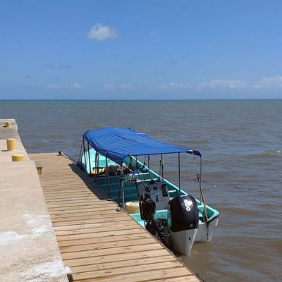 Small boat with plastic rooftop anchored to dock