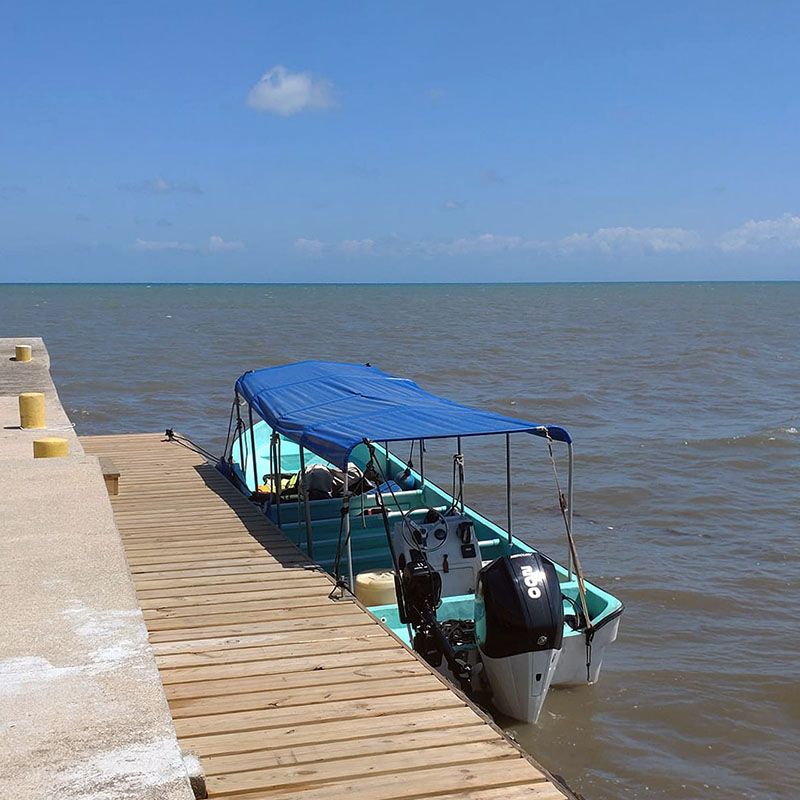 small boat with plastic rooftop anchored to dock