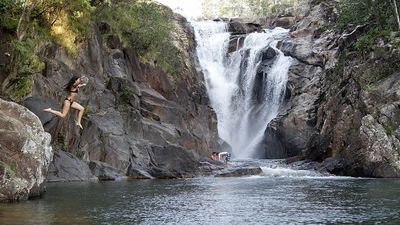 girl jumping into waterfall