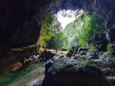 man standing at entrance of large cave