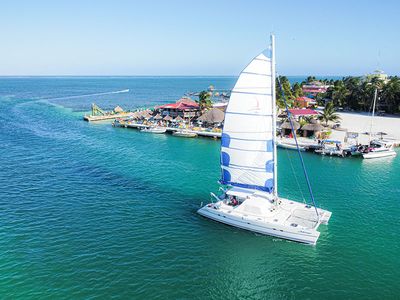 catamaran sailing beside an island