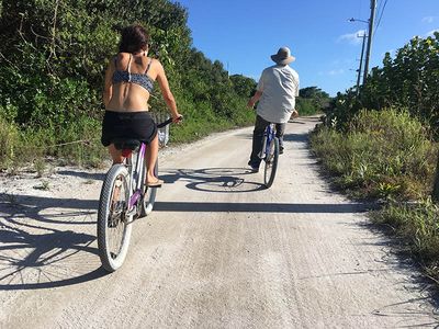 man and woman biking through sandy road