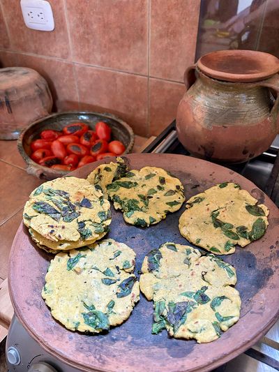 Chipilín tortillas made on traditional comal green vegetable in corn tortilla on stove top