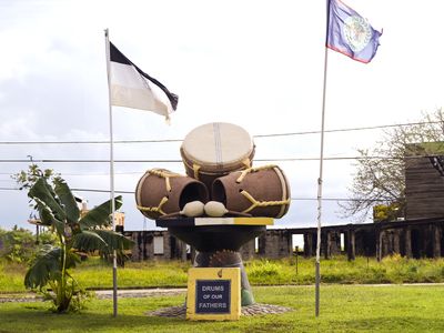 drum statue between two flags