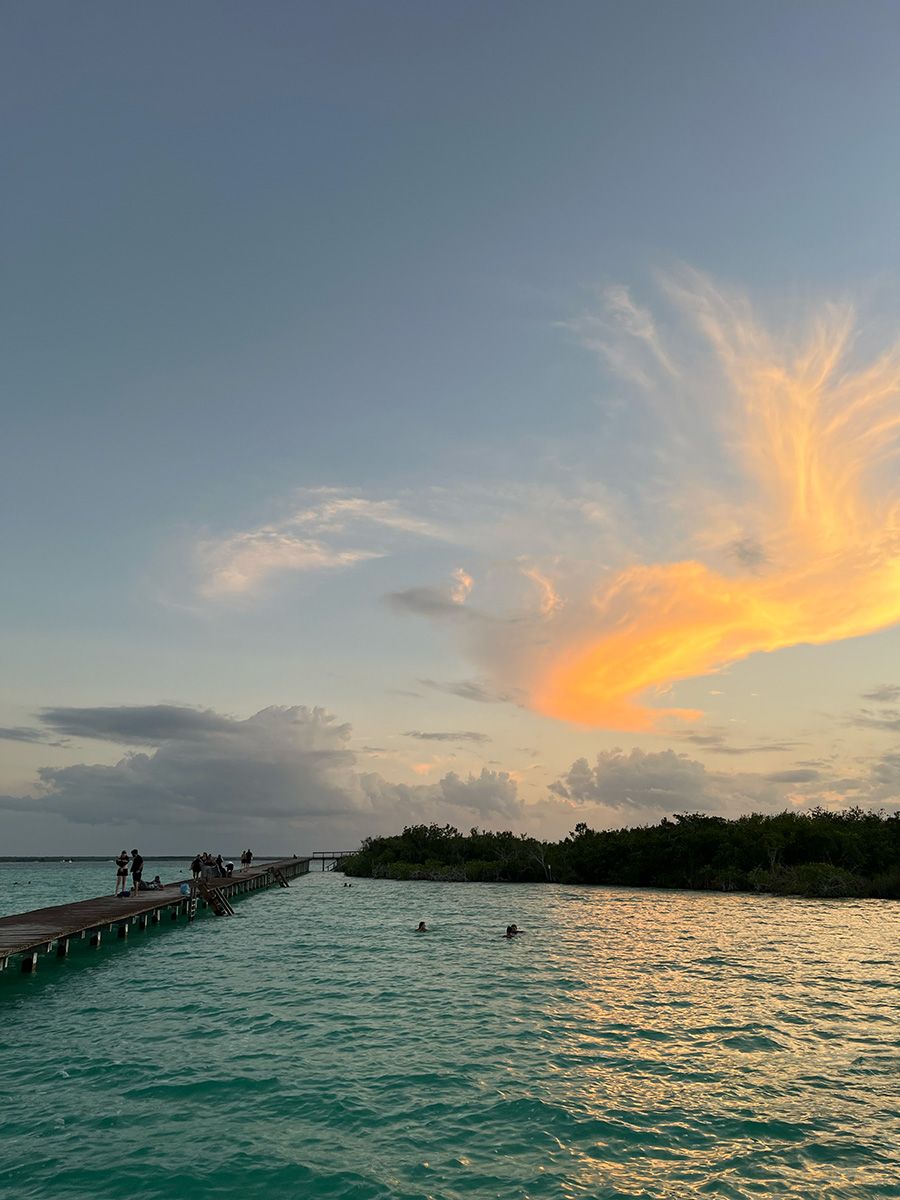 boardwalk over colorful lagoon during sunset