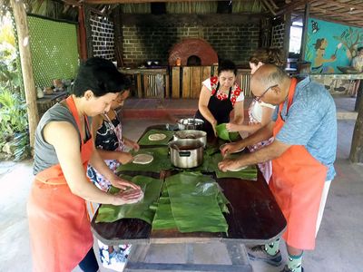 family preparing food on banana leafs on a table