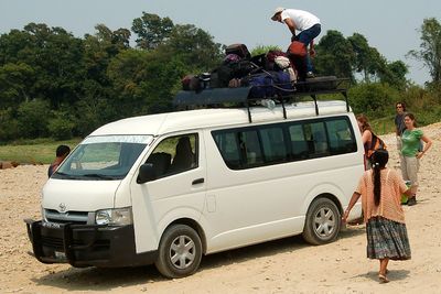 white shuttle van with luggage on top