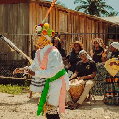 Garifuna dance in Belize by Delly SixMilly masked man dancing in front of drummers