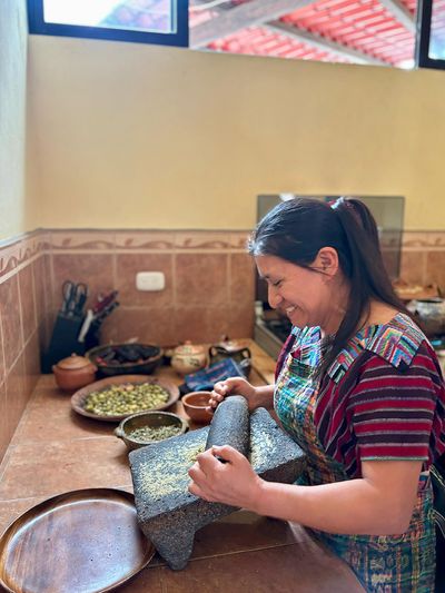Alicia teaching us how to use the traditional grinding stone mayan lady using grinding stone