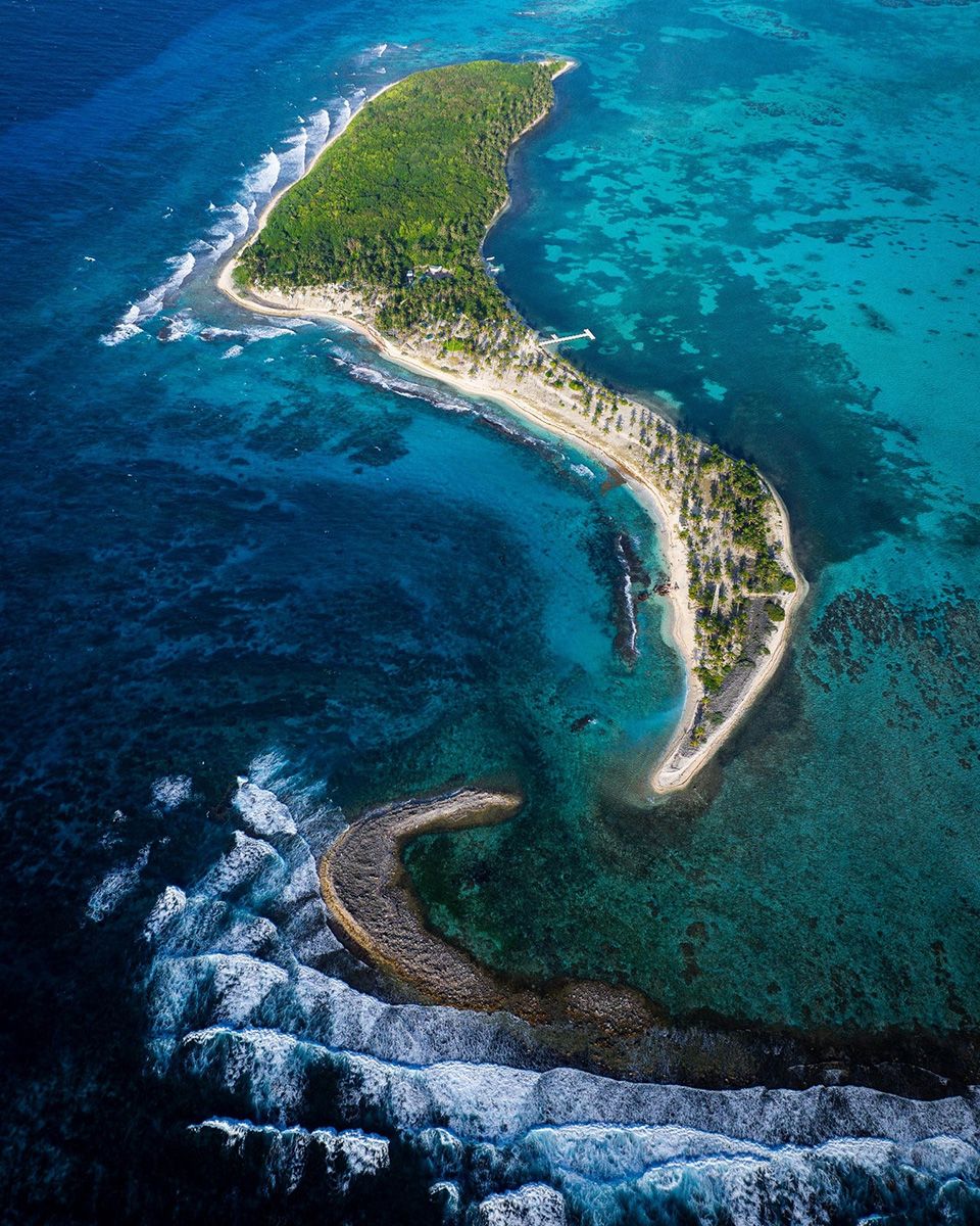 crescent shaped island with reef in front
