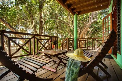 wooden lounge chairs in verandah in front of beach