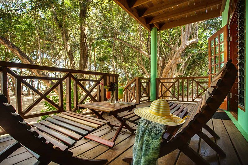 wooden lounge chairs in verandah in front of beach