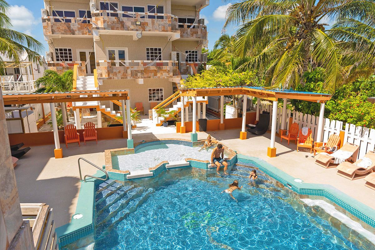 family in pool with building in background
