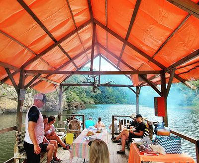 wooden pontoon floating down the river with people