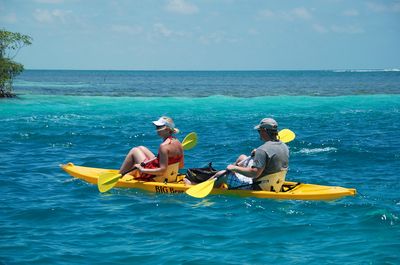 couple rowing on yellow kayak
