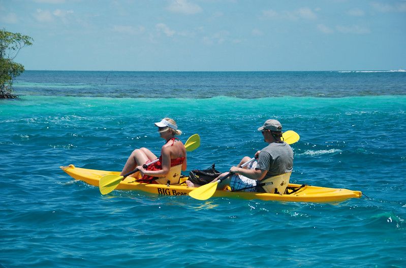 couple rowing on yellow kayak