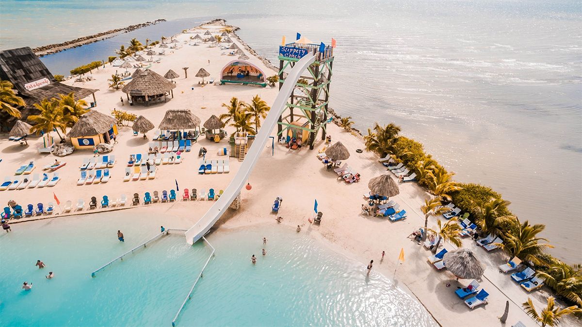 aerial of artificial sandy beach with giant slide and beach chairs