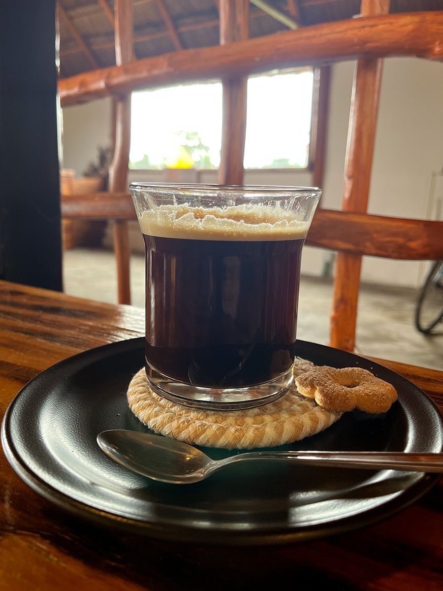 coffee in transparent up with biscuit beside it