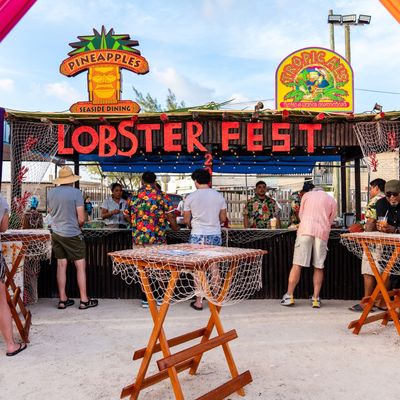 Lobster Festival stall by Ramon's Village Resort festival stall with tourists and tables in front