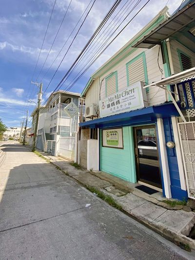 side view of white wooden house with chinese sign