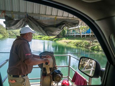 Man operating hand-cranked ferry by Brandon Rosenblum man operating hand-cranked ferry