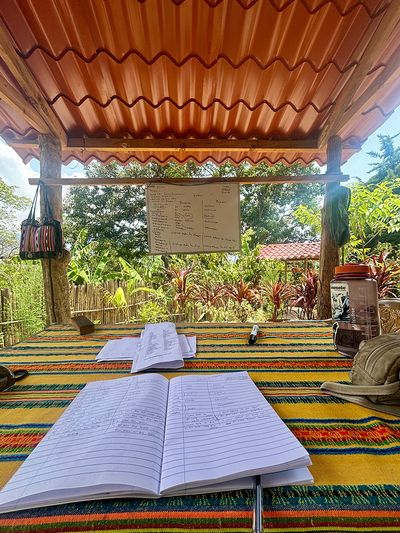 Point of view of a Maya Magic School student notebook on table overlooking whiteboard