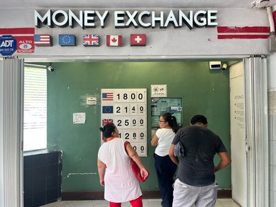 Money Exchange located inside ADO Cancún money exchange sign with people underneath