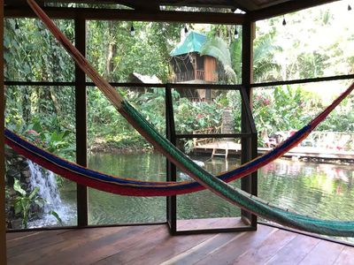 natural pool in background from verandah with hammocks