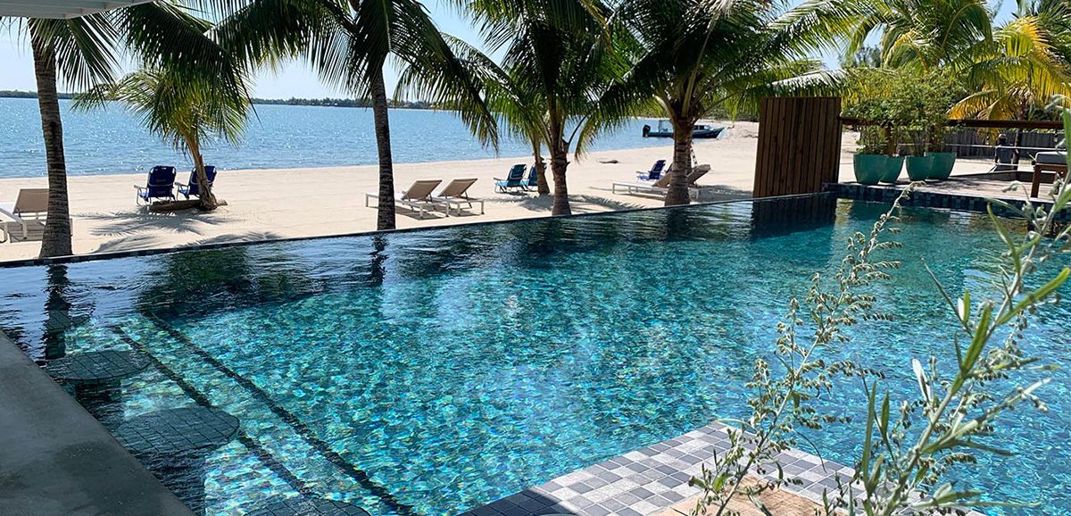 pool in front of beach with beach chairs laid out