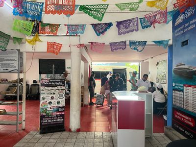 Inside of terminal for Playa Del Carmen To Tulum Colectivo mini van terminal with signage on walls