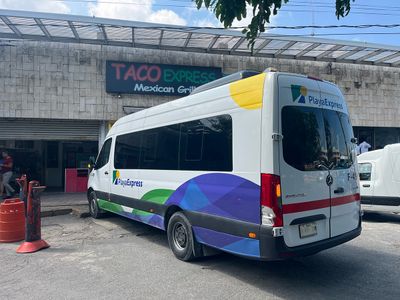 Playa Express Colectivos located in front of ADO Cancún Terminal parked mini white van with some colors