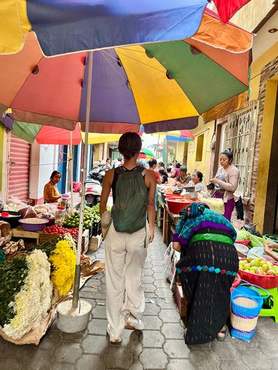 San Pedro Market Day girl with backpack walking through colorful market