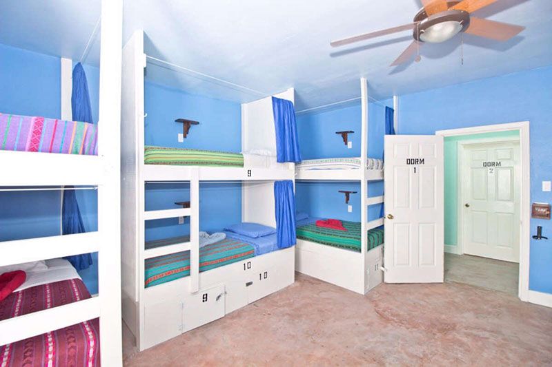 three sets of bunk beds in blue room
