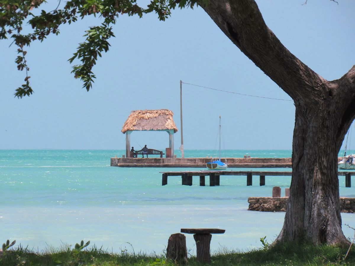 tiny thatch house on dock surrounded by clear water