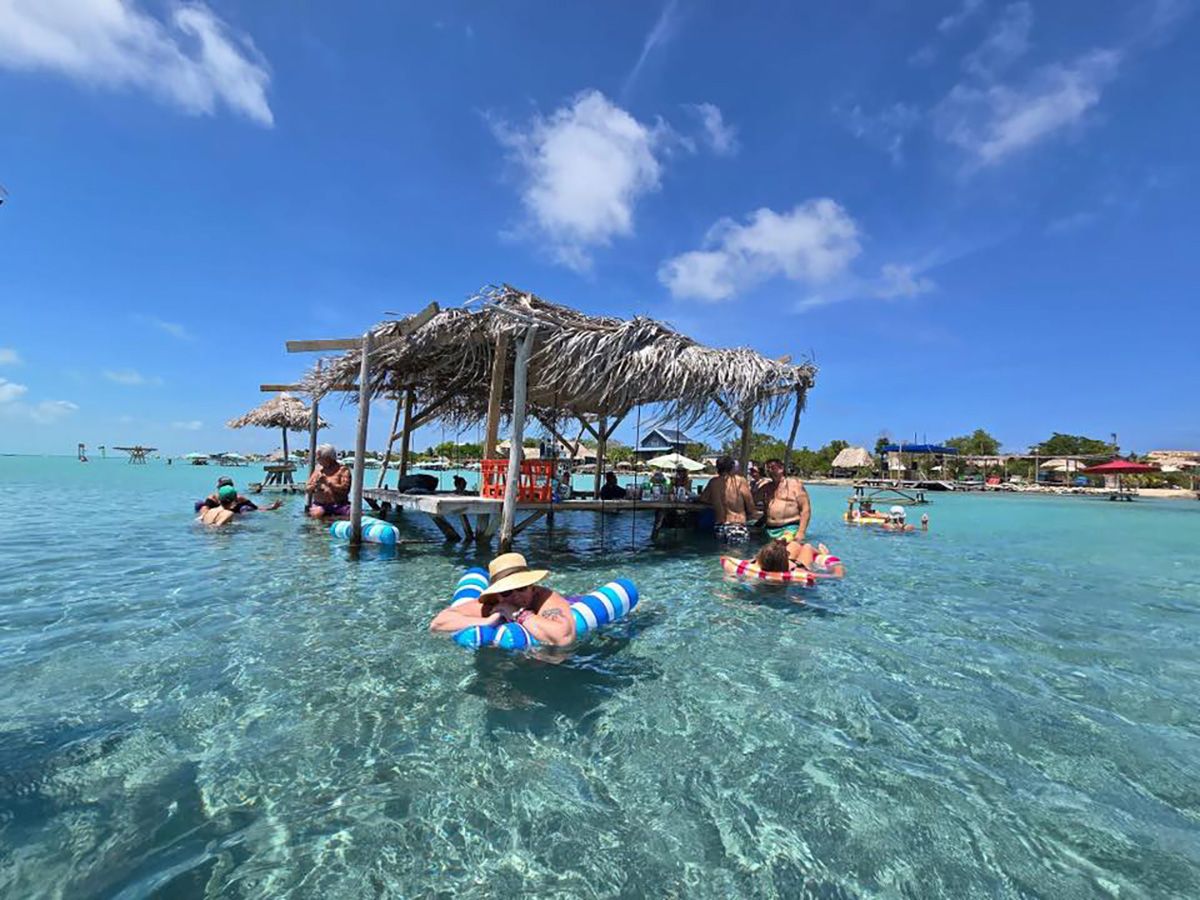 adults with floaties in water with mini bar inside