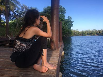 woman watching birds through binoculars