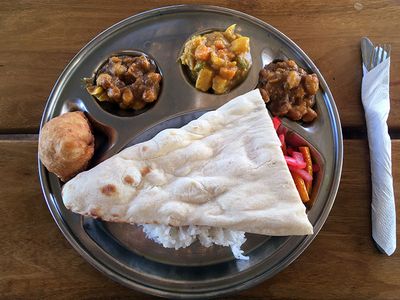 roti with curry stews on metal plate