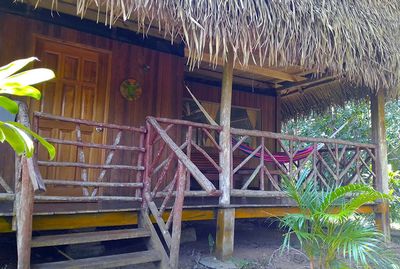 thatched roof cabin with hammock in verandah