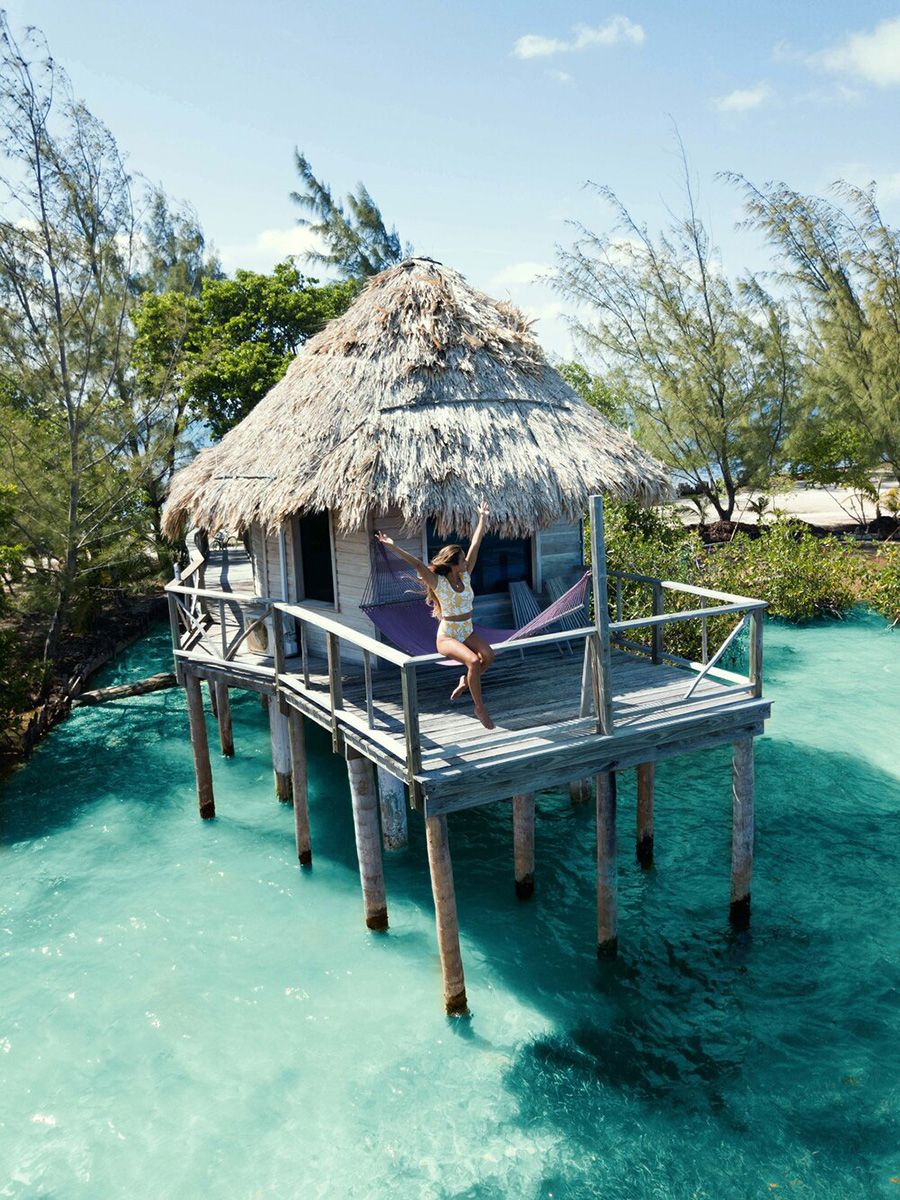 woman sitting in railing of overwater bungalow