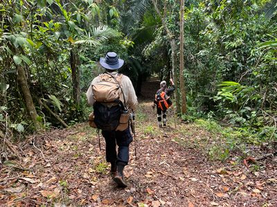 man and woman walking down trail