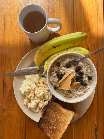 Delicious breakfast at the hostel oatmeal with banana and eggs with toast on plate