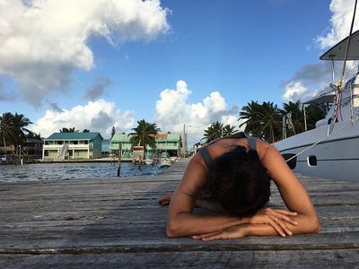 woman doing yoga on a dock at sunrise